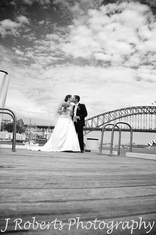 B&W bride and groom kissing on pier sydney harbour - wedding photography sydney